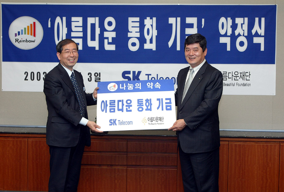 Moon Soo Pyo (on right), president of SK Telecom, and Won Sun Park, lawyer of The Beautiful Foundation (on left) are shown shaking hands after signing an agreement regarding fund donations.